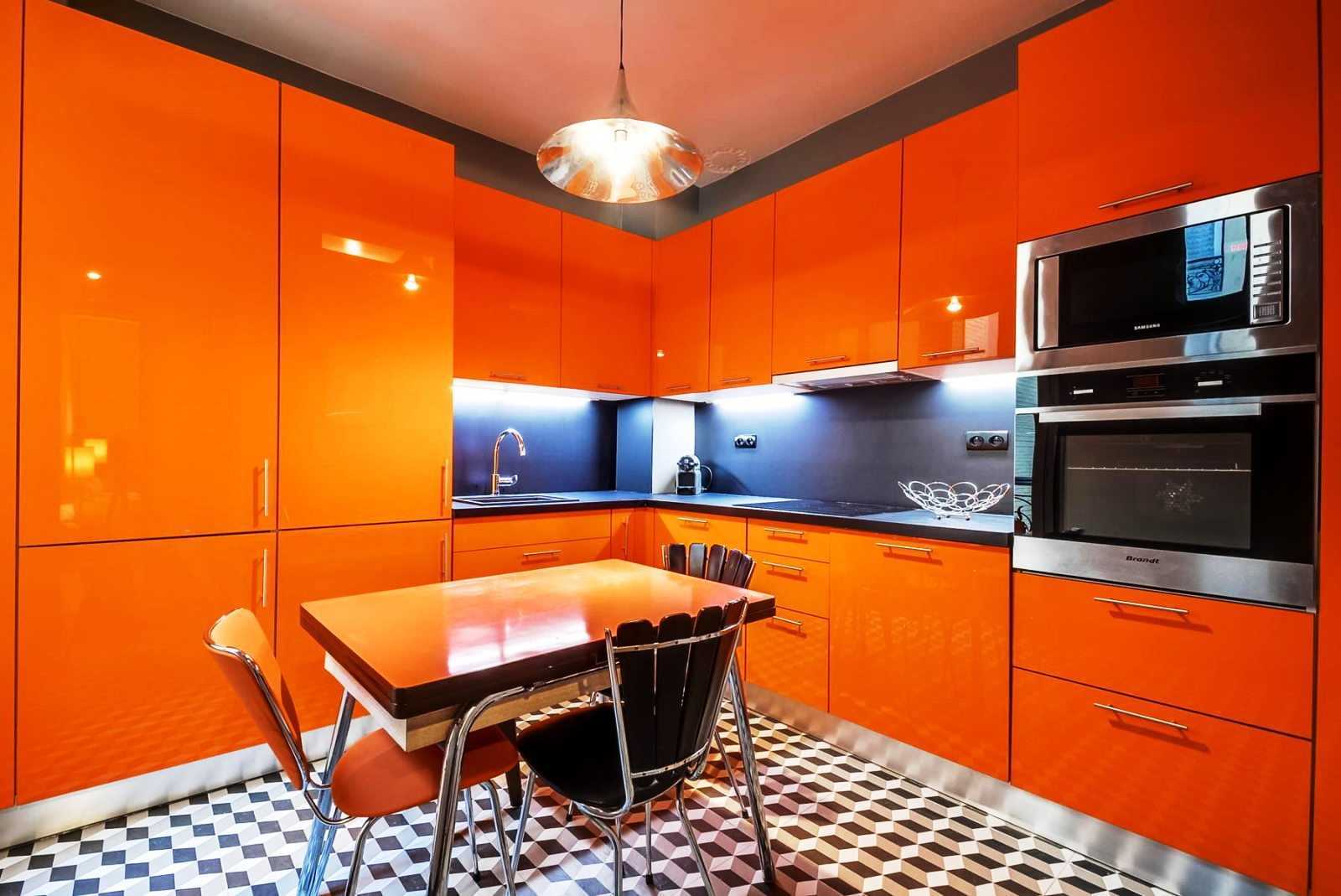 Сине-оранжевый гарнитур на маленькой кухне Компактность и эргономичность Обеденная группа у окна